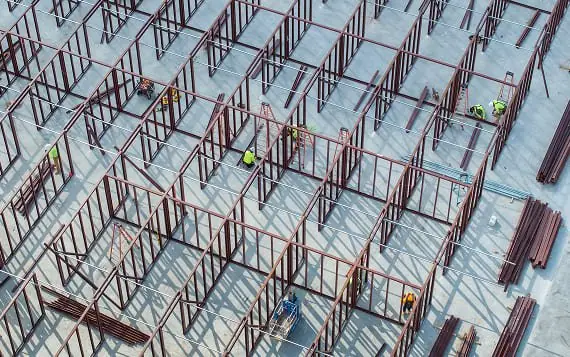Steel framework for commercial construction site with workers.