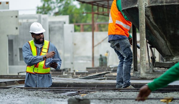 Construction workers pouring concrete at a building site in California.