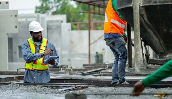 Construction workers pouring concrete at a building site in California.