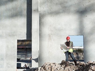 Construction worker inspecting concrete wall at G&G Concrete Inc site.