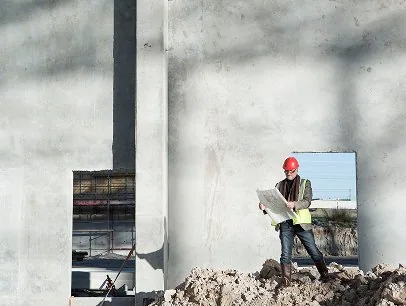 Construction worker inspecting concrete wall at G&G Concrete Inc site.